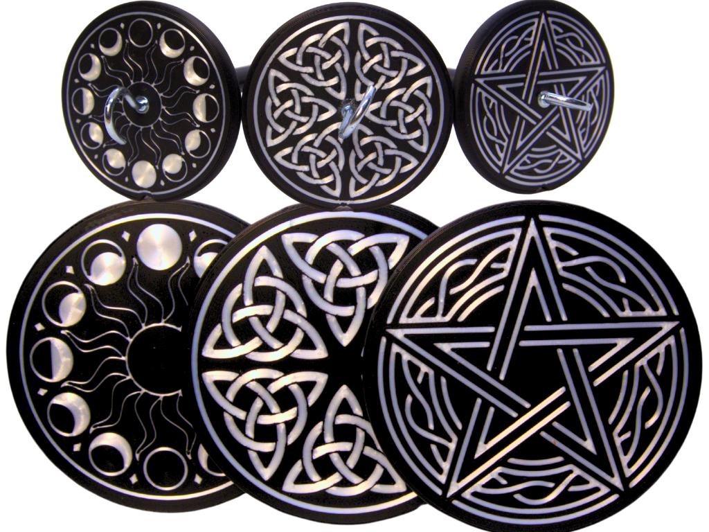 Set of six black and pearlescent circular designs with star and moon patterns on a white background to show the designs available for the drop spindles