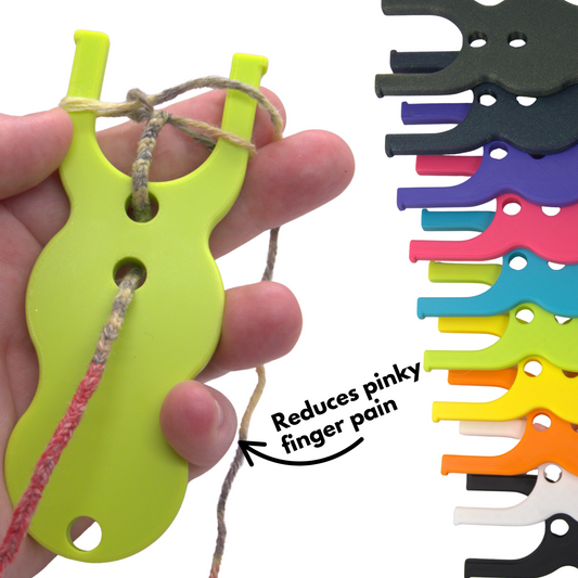 Lime green lucet cord maker being held by a hand with the same tool in a variety of different colours in the background. Text reads 'reduces pinky finger pain'