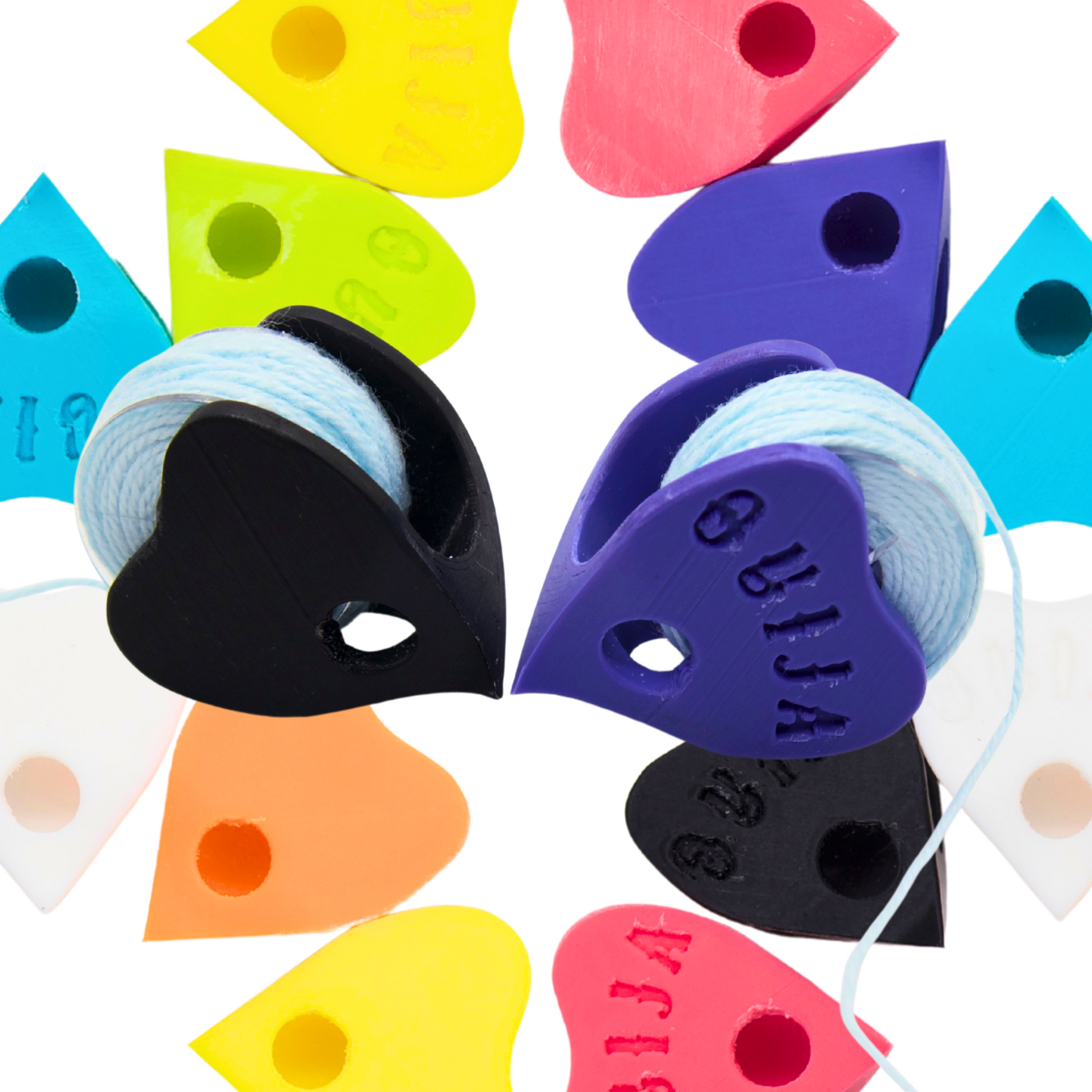 black and purple ouija board plancette shaped tatting shuttles, one with the ouija text on it, both with sewing machine bobbins inside