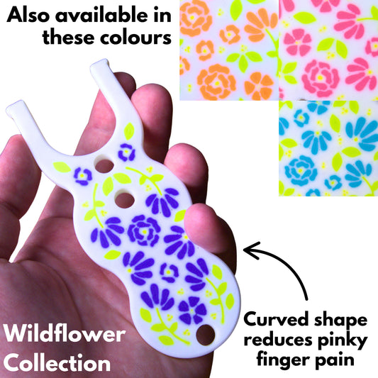a lucet fork for making viking braiding in a white and purple floral pattern. Text remarks the curved shape reduces pinky finger pain and that the item is part of the wildflower collection and is also available in other colourways